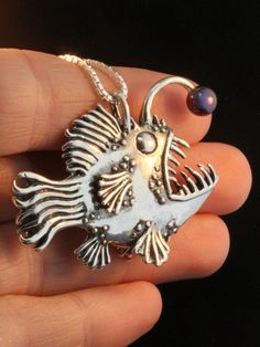 "This impressive Angler Fish Pendant is cast in solid sterling silver. It grins with wicked fangs, wears feathery fins and sports a tempting lure tipped with a 6 mm cultured black pearl. This monster of the deep is 1 1/2\" high and 2\" long and completely three dimensional. Beauty is in the eyes of the beholder. All Marty Magic Charms and Pendants include an 18 inch (46cm) box chain. If you would prefer a different length of chain please feel free to contact me. All Marty Magic Jewelry is packag Lantern Fish, Fish Monster, Scary Fish, Unique Ear Cuffs, Dragon Ear Cuffs, Magic Jewelry, Magic Charms, Fish Jewelry, Fish Necklace