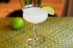 a margarita sitting on top of a table next to a lime