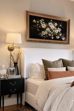 a bedroom with a large painting above the bed