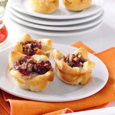 mini cranberry and pecan pies on a white plate with orange napkin