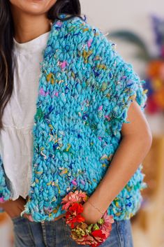 a woman wearing a blue shawl with flowers on it