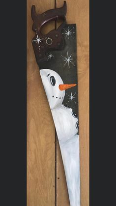 an upside down snowman is hanging on the wall next to a pair of scissors