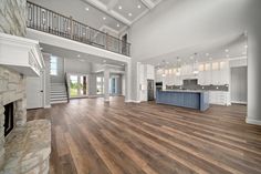 a large open floor plan with wood floors and white walls, stairs leading up to the second story