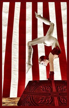 a woman doing a handstand on top of a red object in front of an american flag