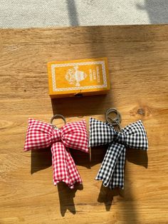 two small bows tied to each other on top of a wooden table next to a box