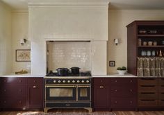 a stove top oven sitting inside of a kitchen next to a counter and cupboards