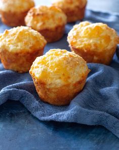 some muffins are sitting on a blue cloth