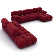 a large red couch sitting on top of a white floor next to a chair and ottoman