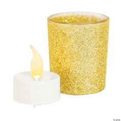 a candle that is next to a cup with glitter on it and a white base