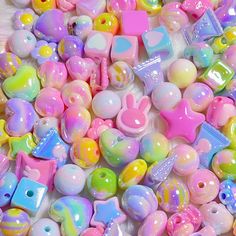 there are many different types of beads on the table and one is pink, yellow, blue, green