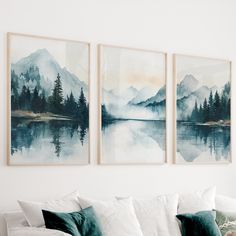 three watercolor paintings hang on the wall above a white couch in a living room