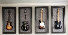 four guitars are hanging on the wall