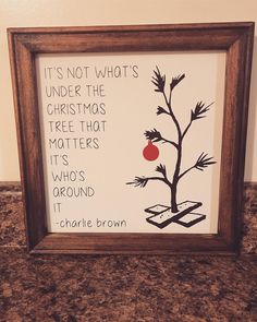 there is a picture frame with a christmas tree and a quote on the bottom that says it's not what's under the christmas tree that matters its whos around