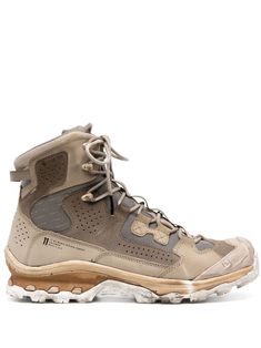 a pair of hiking boots with laces on the top and bottom, in beige