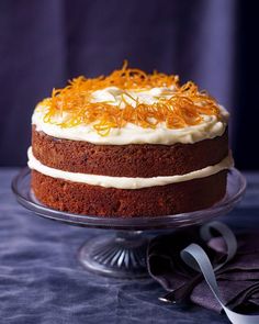 a cake with white frosting and orange sprinkles sitting on a glass plate