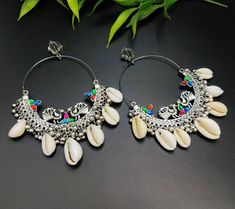 Adorn your daily attire with ethnicity & add glam to your personality with this high-quality handcrafted shell earrings. Compliment your outfit with this set of Indian jewellery on any given day and dazzle people with your elegant aura. You'll be sure to receive compliments when you wear this exquisite piece of german jewellery. Pair it up with any attire & make sure to brighten up your outfit on any given day. You can also put on this set with semi- formal attire to make you feel the best versi Oxidized Finish Chandbali Hoop Earrings, Traditional Nickel-free Danglers, Cowrie Shell Earrings, Cowrie Shell Jewelry, German Jewelry, Peacock Motifs, Chandbali Earrings, Earrings Hoops, Indian Earrings