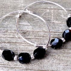 These handcrafted black hoop earrings are perfect for everyday wear! Silver plated 30mm hoops strung with gorgeous faceted Black Czech glass beads. Simply stunning! Item is carefully packaged and shipped via USPS in a sturdy protective mailer. Check out more fabulous jewelry and enter my shop here: https://www.etsy.com/shop/jewelbytessyla View the positive feedback I've received from customers and check out some beautiful art prints for nursery and home at my print shop, Tessyla: https://www.ets Black Bead Earrings, Black And Silver Earrings, Black Hoop Earrings, Tropical Necklace, Pink Gemstone Necklace, Prints For Nursery, Black Hoops Earrings, Abalone Earrings, Black Earrings Dangle