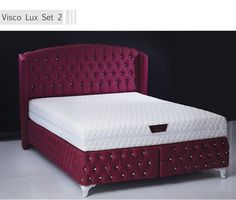 a bed with a red velvet headboard and foot board is shown in this image