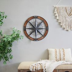 a clock mounted to the side of a wall next to a bench and potted plant