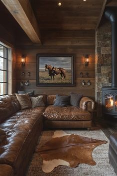 a living room with leather couches and a horse painting on the wall above it