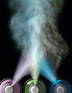 three cans with colored powder coming out of them