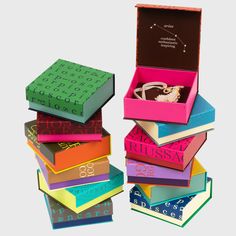 a stack of colorful books sitting on top of each other next to a book box