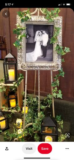 a wedding photo frame with candles and greenery