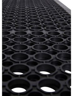 a large metal grate filled with lots of black circles on it's side