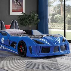 a blue race car bed in a bedroom