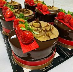 several chocolate cakes with strawberries on top