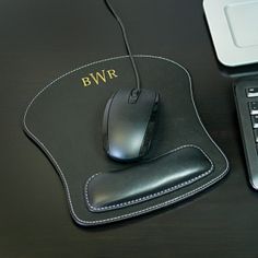 a computer mouse sitting on top of a black desk next to a keyboard and laptop