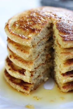 a stack of pancakes sitting on top of a white plate covered in powdered sugar