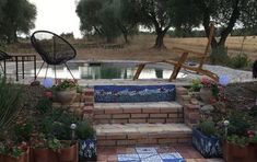 an outdoor patio with stone steps leading up to a pond