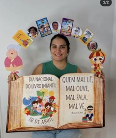 a woman is holding an open book with spanish words on it and pictures around her