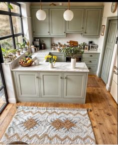 a kitchen with green cabinets and an area rug in front of the counter top that has flowers on it