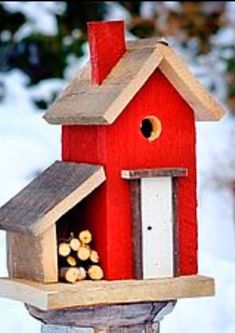 a red bird house with logs in it