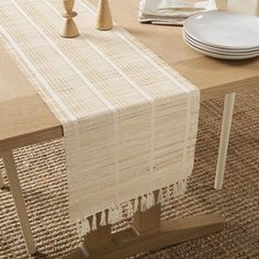 the table is set with plates, silverware and a placemat on it in front of an empty plate