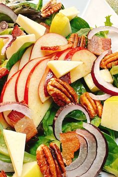 a salad with apples, cheese and pecans on it