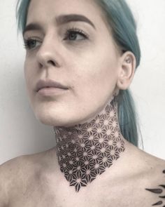 a woman with green hair and tattoos on her neck