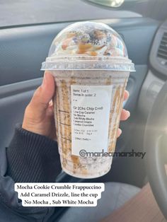 a person holding up a cup of ice cream in their hand with the words mocha cola crumble frappuccino and caramel on it