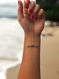 a woman's arm with a small tattoo on the wrist that reads, mother