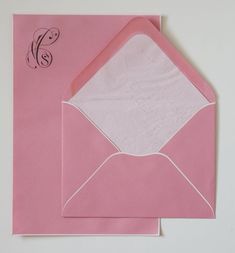 a pink envelope with a monogrammed letter on it