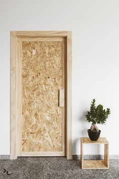 a potted plant sitting on top of a wooden table next to a door that is partially open