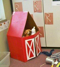 a child's playroom with toys and letters on the walls, including a red barn