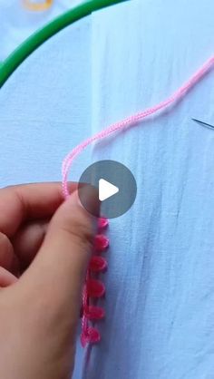 someone is stitching something with pink thread