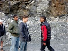 four men standing in front of a rocky mountain