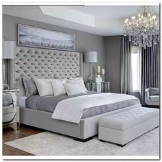 a bedroom with a large bed and chandelier