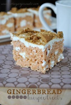 a piece of cake sitting on top of a wooden cutting board next to a cup