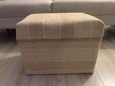 a beige ottoman sitting on top of a hard wood floor