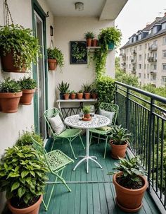 an apartment balcony with potted plants on the balconies and table for two